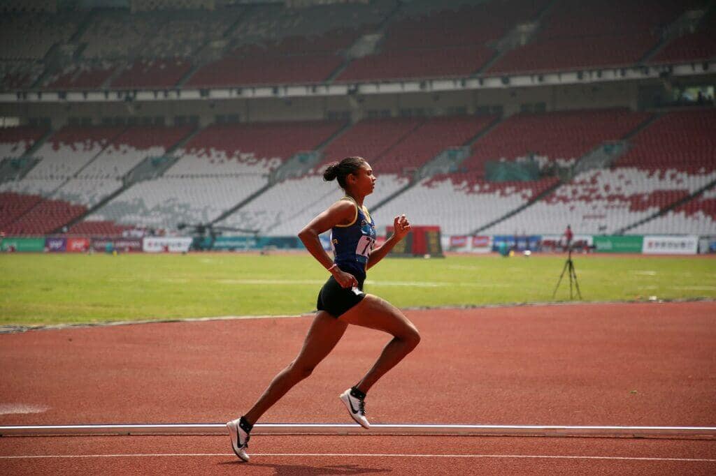 An image showing a female runner on the track.
