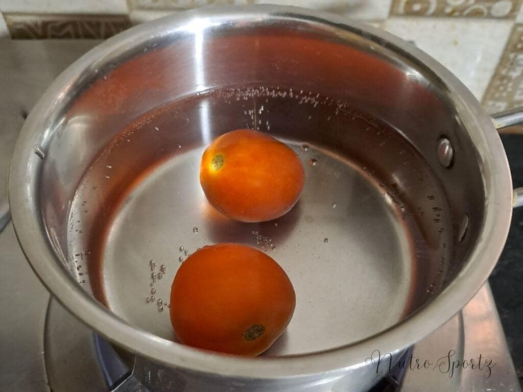 An image of tomatoes getting blanched in a pan.